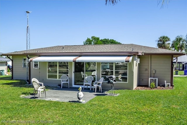 back of property with a patio area and a yard