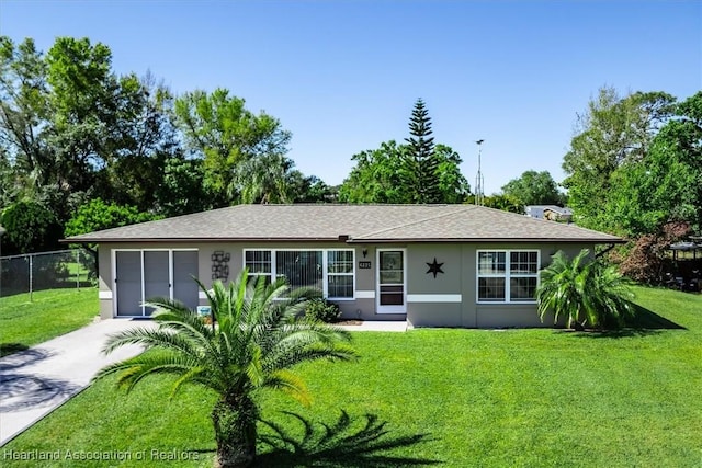 ranch-style house with fence, driveway, stucco siding, a front lawn, and a garage