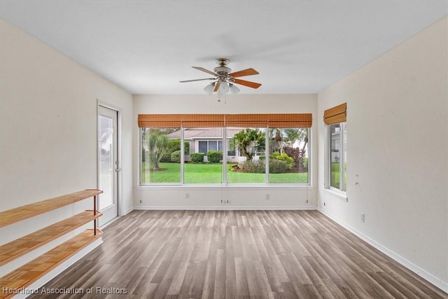 unfurnished room with ceiling fan and hardwood / wood-style flooring