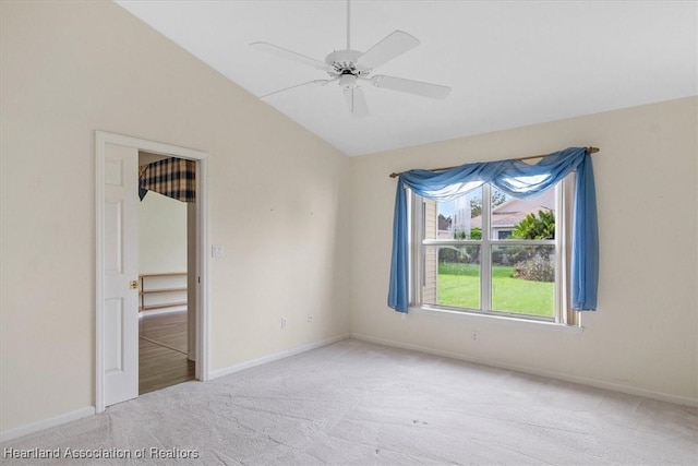 carpeted spare room with ceiling fan and lofted ceiling