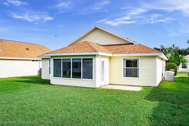 back of house with central AC unit and a lawn