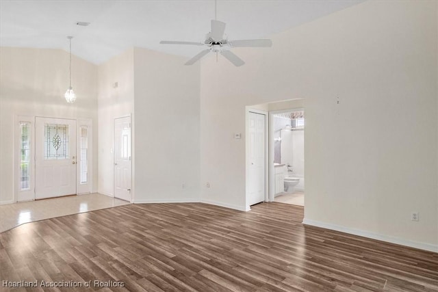 interior space featuring dark hardwood / wood-style floors, high vaulted ceiling, and ceiling fan