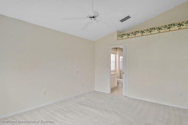 spare room featuring light colored carpet, ceiling fan, and lofted ceiling