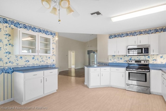 kitchen featuring white cabinets, ceiling fan, light wood-type flooring, and appliances with stainless steel finishes