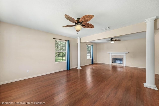 unfurnished living room with decorative columns, ceiling fan, and dark hardwood / wood-style flooring