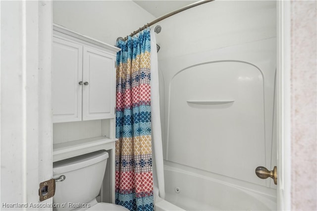 bathroom featuring shower / tub combo and toilet