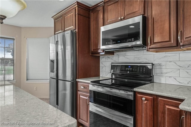 kitchen featuring light stone countertops and appliances with stainless steel finishes