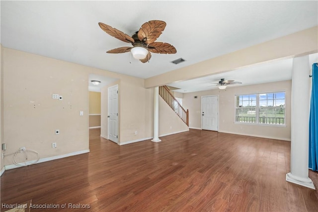 unfurnished living room with dark hardwood / wood-style flooring, decorative columns, and ceiling fan