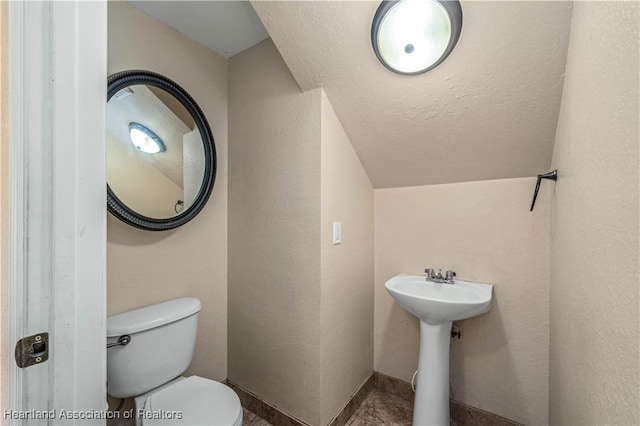 bathroom with toilet and a textured ceiling