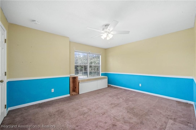 carpeted spare room with ceiling fan