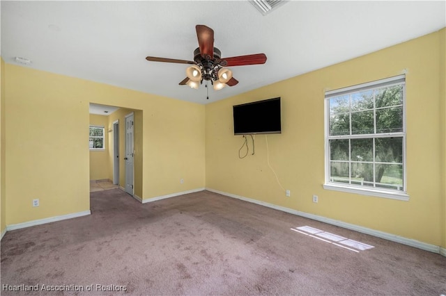 carpeted spare room featuring ceiling fan