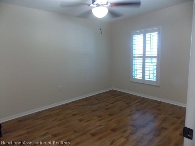 empty room featuring ceiling fan and dark wood-type flooring