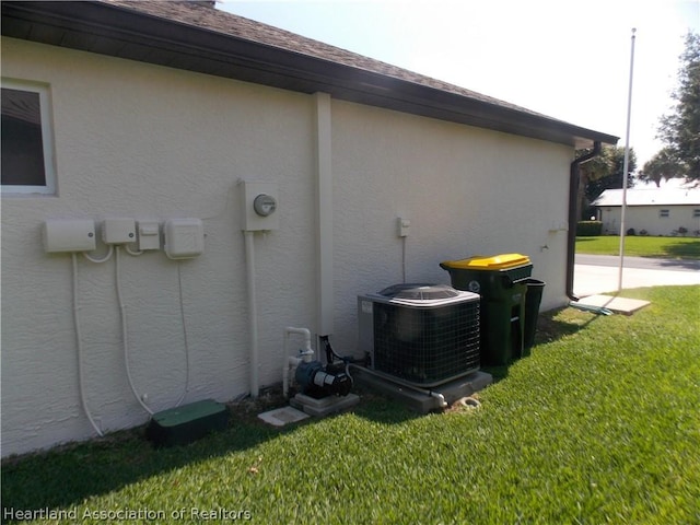 view of side of home with a lawn and central AC unit