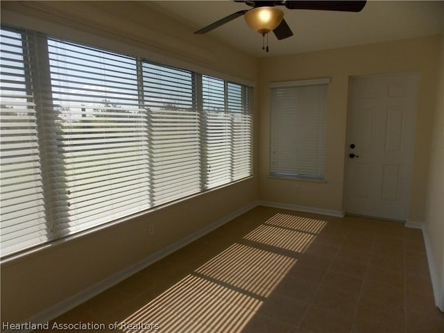 unfurnished sunroom with a wealth of natural light and ceiling fan