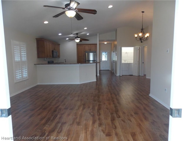 kitchen featuring stainless steel refrigerator, dark wood-type flooring, kitchen peninsula, lofted ceiling, and ceiling fan with notable chandelier