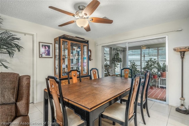 tiled dining space featuring ceiling fan and a textured ceiling