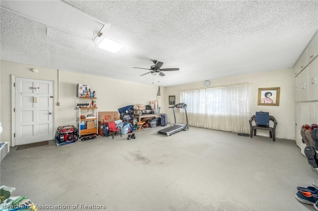 exercise room with ceiling fan and a textured ceiling