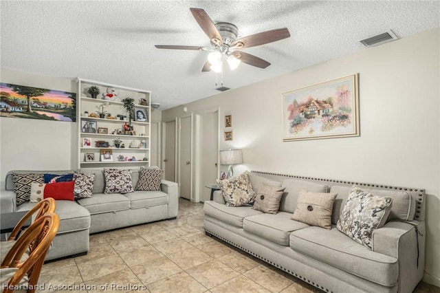 tiled living room featuring ceiling fan and a textured ceiling