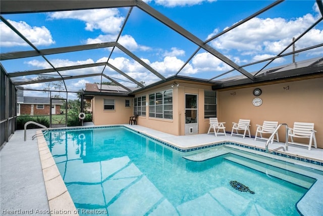 view of swimming pool featuring glass enclosure