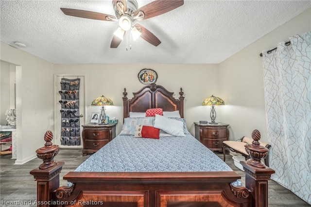 bedroom with ceiling fan, dark hardwood / wood-style flooring, and a textured ceiling