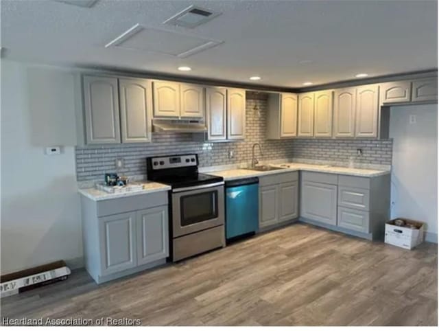 kitchen featuring decorative backsplash, wood-type flooring, stainless steel appliances, and sink