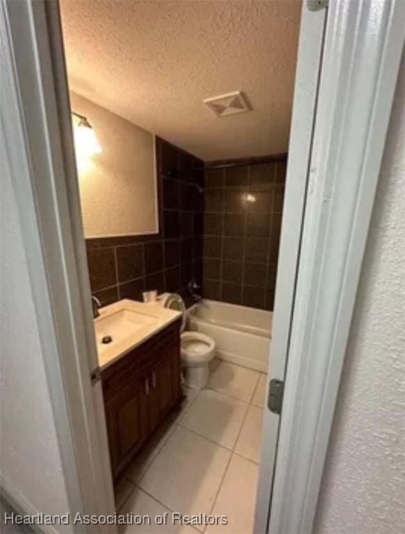 full bathroom featuring tile patterned floors, vanity, a textured ceiling, tile walls, and toilet