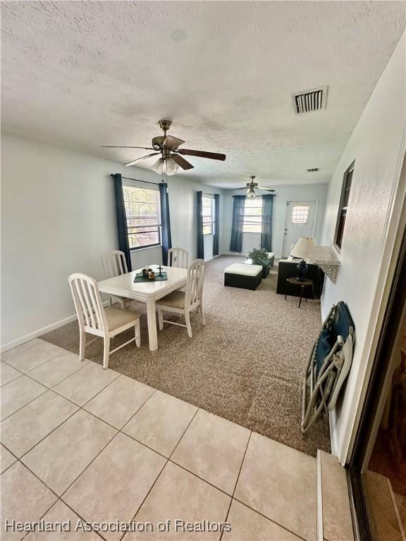 302 Whatley Blvd, Sebring, FL 33870 - dining area with a textured ceiling, light colored carpet, light tile patterned flooring, baseboards, and a ceiling fan