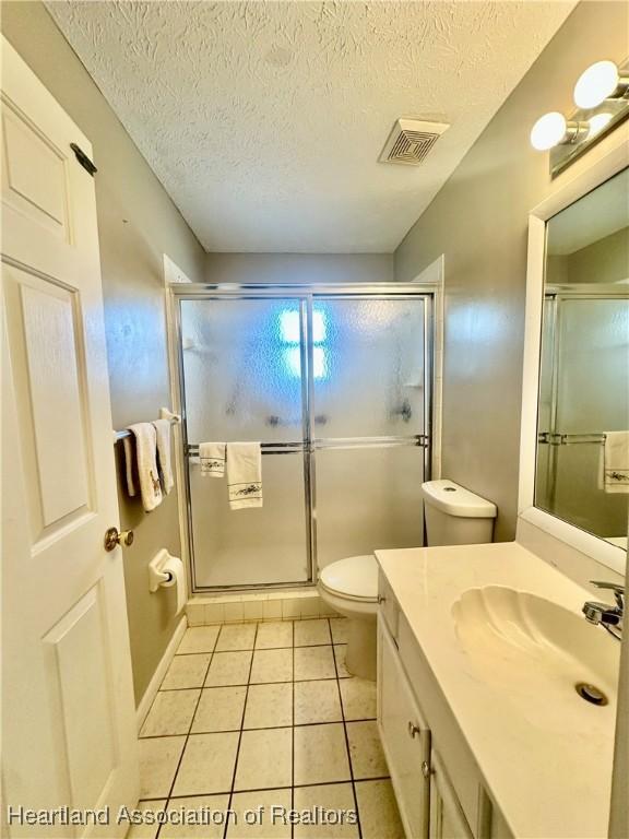 302 Whatley Blvd, Sebring, FL 33870 - full bath with vanity, toilet, a stall shower, tile patterned floors, and a textured ceiling