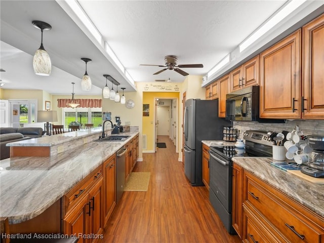 123 Harry Lee Rd, Lake Placid, FL 33852 - kitchen featuring stainless steel appliances, light stone countertops, sink, and decorative light fixtures