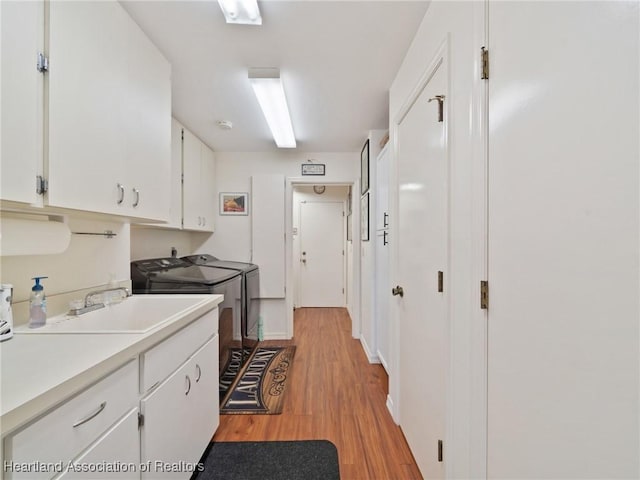 123 Harry Lee Rd, Lake Placid, FL 33852 - kitchen with sink, white cabinets, washer and clothes dryer, and light hardwood / wood-style floors