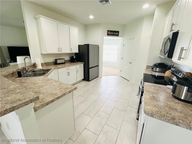 5310 Pebble Dr, Sebring, FL 33872 - kitchen with stainless steel appliances, white cabinetry, a peninsula, light countertops, and recessed lighting