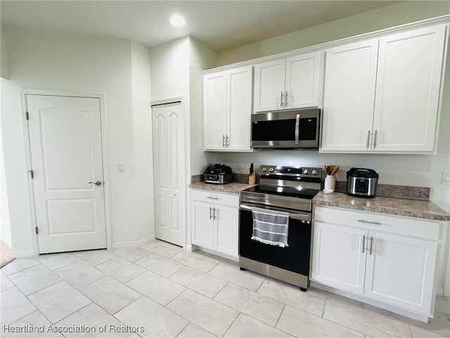5310 Pebble Dr, Sebring, FL 33872 - kitchen featuring stainless steel appliances, white cabinetry, light tile patterned floors, and recessed lighting