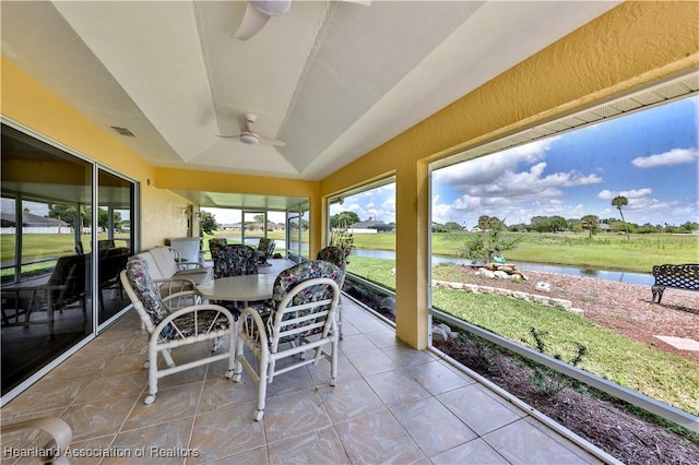 sunroom featuring visible vents, outdoor dining area, a water view, and ceiling fan