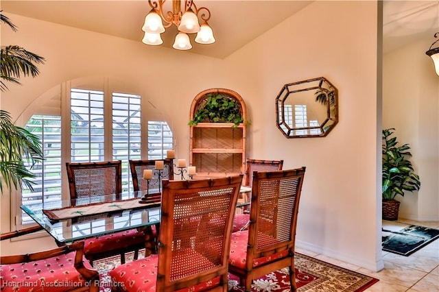 tiled dining area with lofted ceiling, baseboards, and a notable chandelier