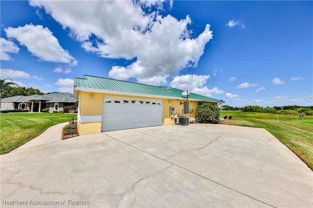 view of front of property featuring stucco siding, metal roof, driveway, a front yard, and a garage