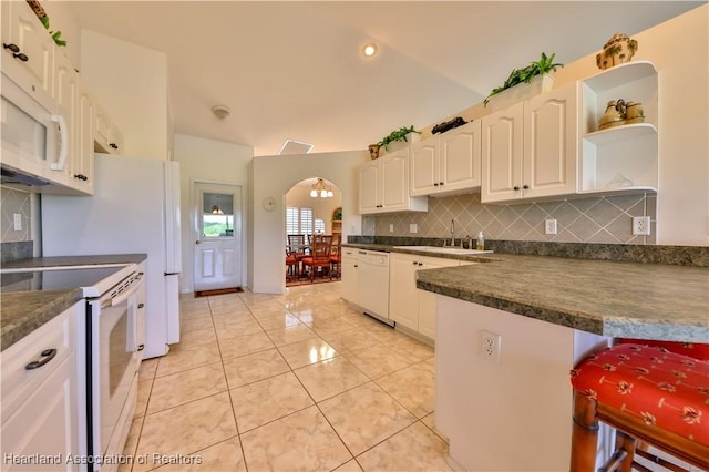 kitchen featuring white appliances, dark countertops, white cabinetry, and open shelves
