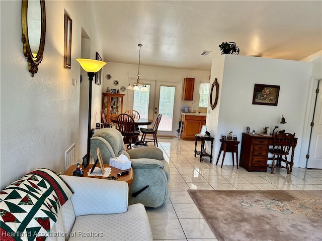 living room featuring an inviting chandelier and light tile patterned floors