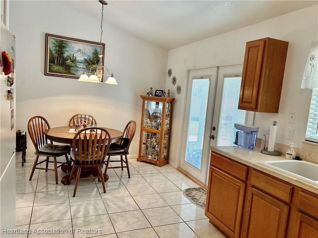 tiled dining area featuring sink and an inviting chandelier