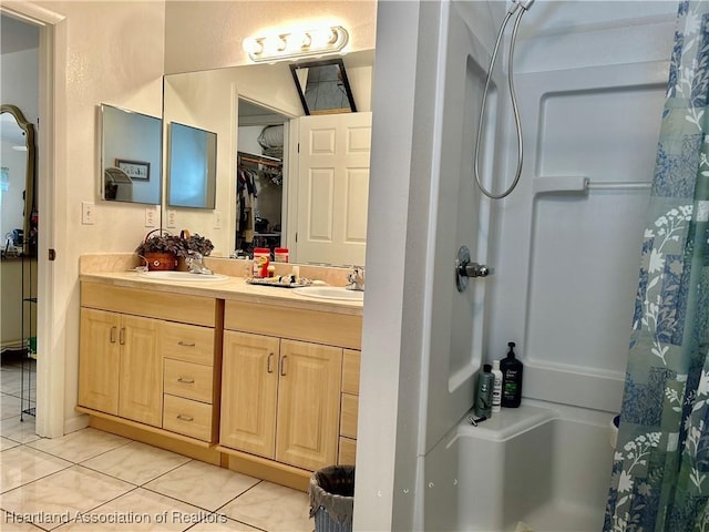 bathroom with tile patterned flooring, walk in shower, and vanity