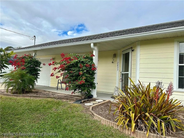 property entrance with a yard and a garage