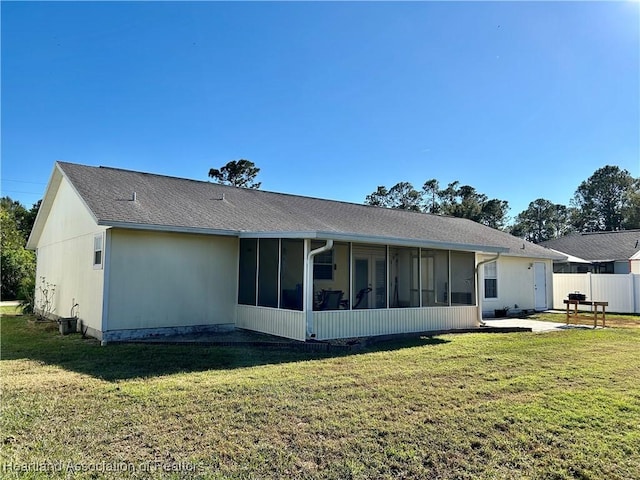 back of house featuring a yard and a sunroom