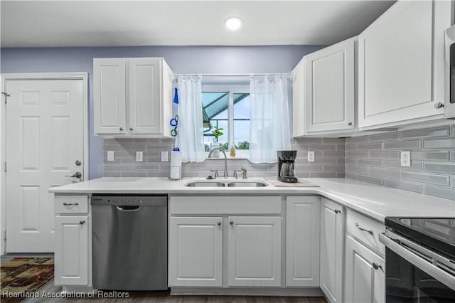 kitchen featuring white cabinets, backsplash, stainless steel dishwasher, and sink