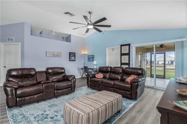 living room featuring vaulted ceiling with beams and light hardwood / wood-style flooring