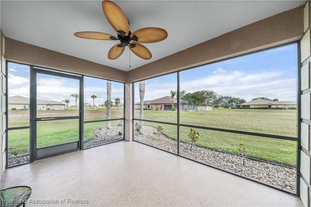 unfurnished sunroom with a wealth of natural light and ceiling fan