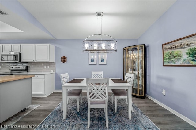 dining room with dark wood-type flooring and a chandelier