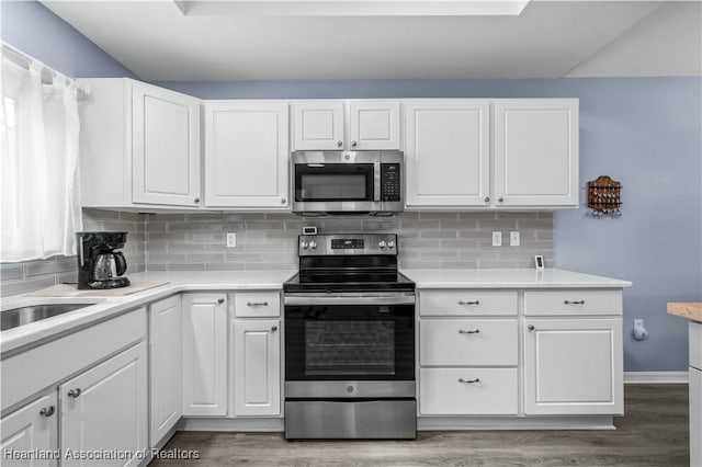 kitchen featuring white cabinets, stainless steel appliances, and tasteful backsplash