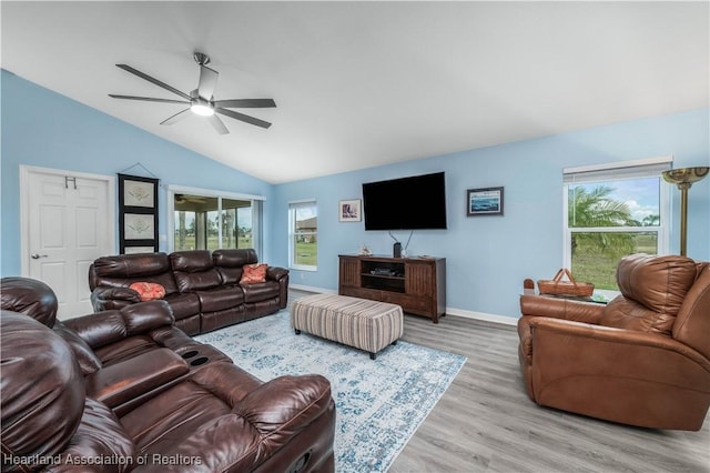 living room featuring ceiling fan, light hardwood / wood-style flooring, and vaulted ceiling