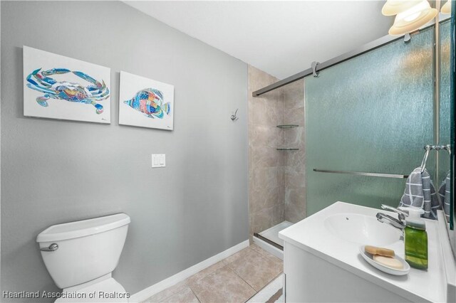 bathroom featuring tile patterned flooring, vanity, an enclosed shower, and toilet