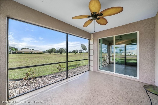 unfurnished sunroom with ceiling fan