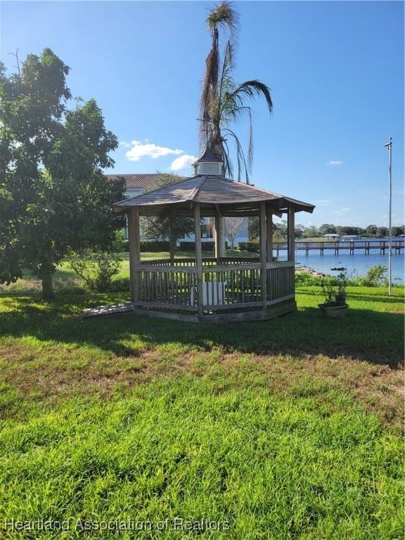 exterior space with a gazebo, a water view, and a lawn